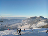 Skieurs sur la piste bleue La Frastaz avec vue sur le Léman