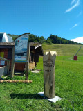 Totem bois pyrogravé Darandel, piste bleue et crêtes d'Hirmentaz-Habère Poche en arrière plan.