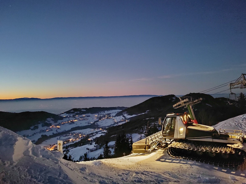 Dameuse au sommet des Crêtes avec vue sur le village d'Habère-poche la nuit Dameuse au sommet des Crêtes avec vue sur le village d'Habère-poche la nuit