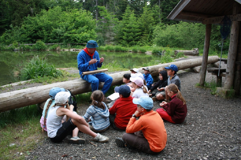 Médiateur devant un groupe d'élèves à côté du lac de Fuzet